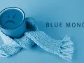 Smutny kubek z uśmiechem, otulony szalikiem, symbolizuje blue monday.