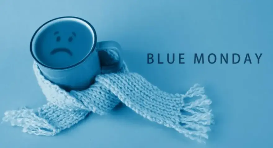 Smutny kubek z uśmiechem, otulony szalikiem, symbolizuje blue monday.
