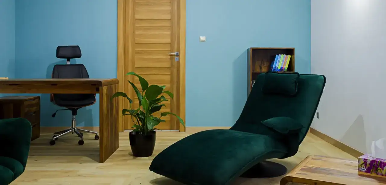 Gabinet terapeutyczny z fotelem do leżenia, biurkiem i rośliną. Miejsce, gdzie można pracować nad zaburzeniami osobowości.
